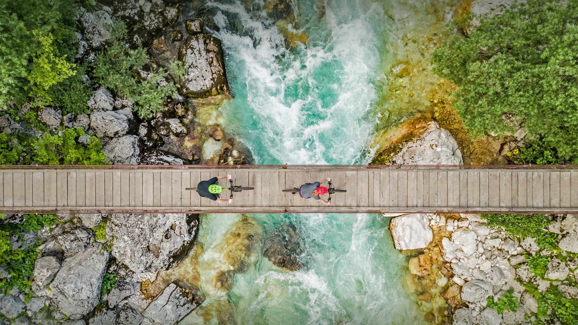 斯洛文尼亚索奇河上的木制吊桥上骑自行车的人的鸟瞰图 (© Amazing Aerial Agency/Offset by Shutterstock)(Bing China)