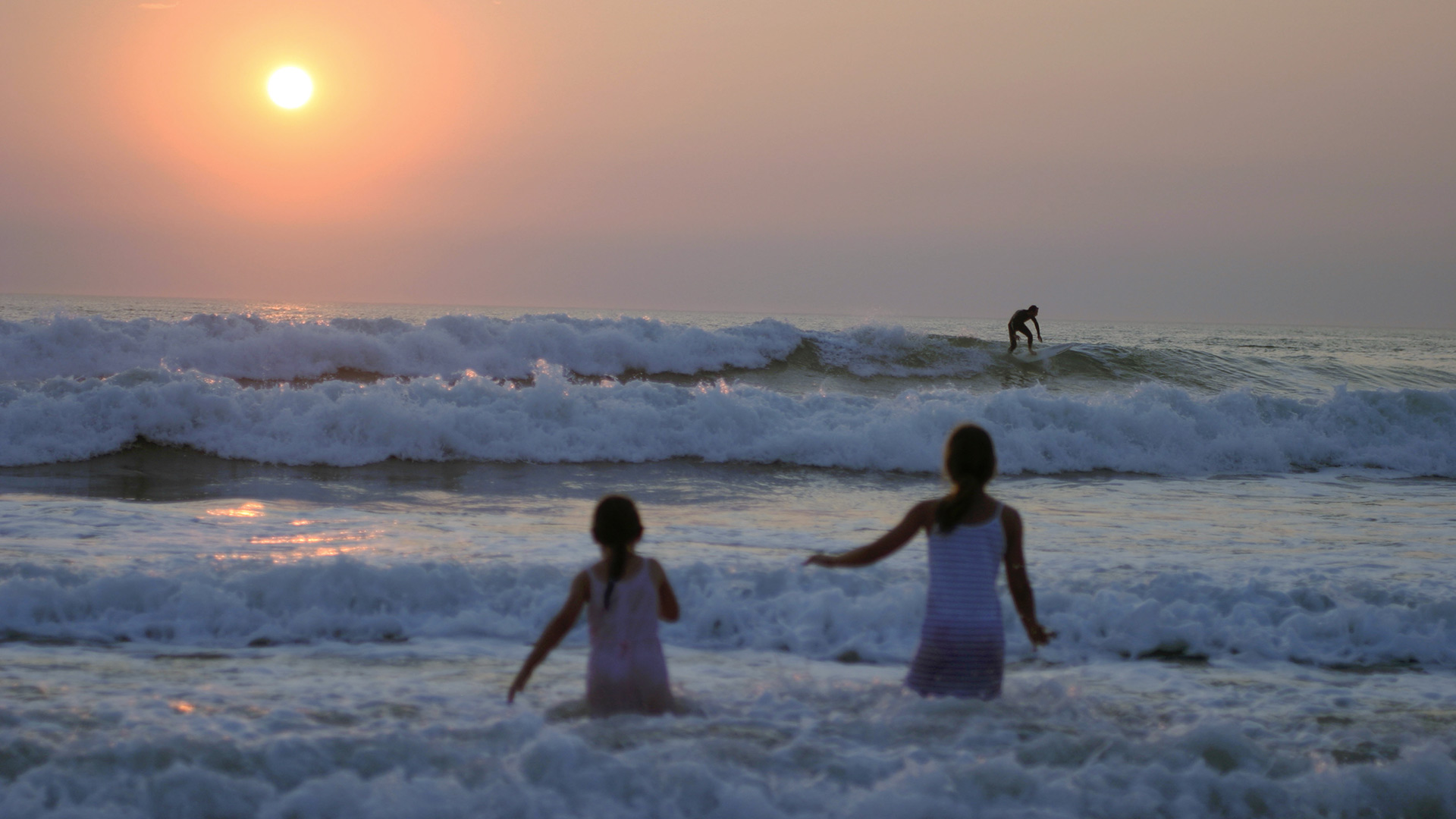Deux fillettes en pleine baignade devant un coucher de soleil à Lacanau, France (© van hilversum/Alamy Stock Photo)(Bing France)