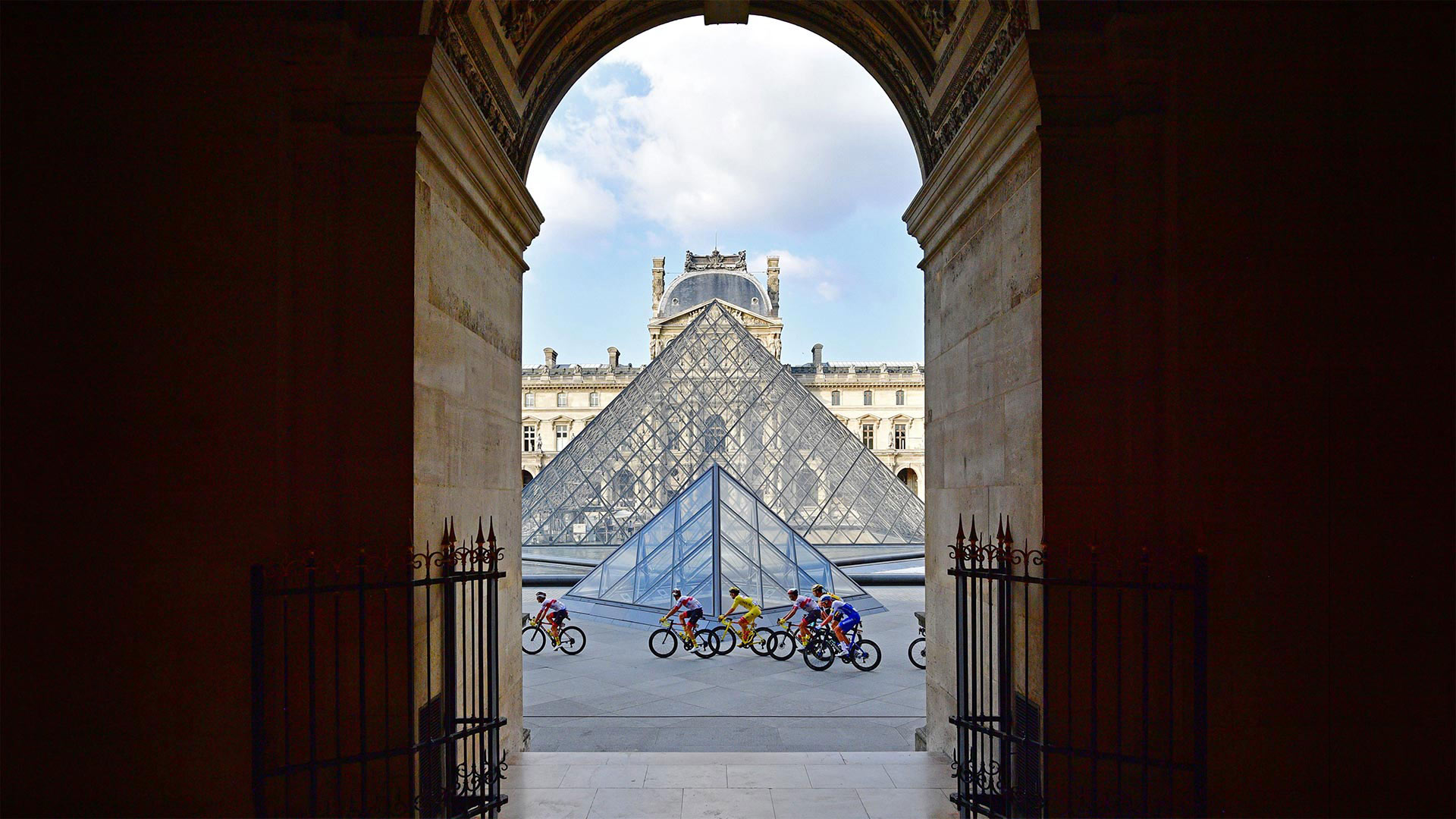 Tour de France riders in front of the Louvre Pyramid and museum in Paris, France, during the 2020 race (© Martin Bureau/AFP via Getty Images)(Bing Canada)