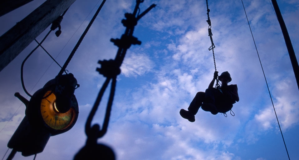A worker returns to earth after lubricating the top of a drilling rig -- Joel Sartore/Getty Images &copy; (Bing United States)