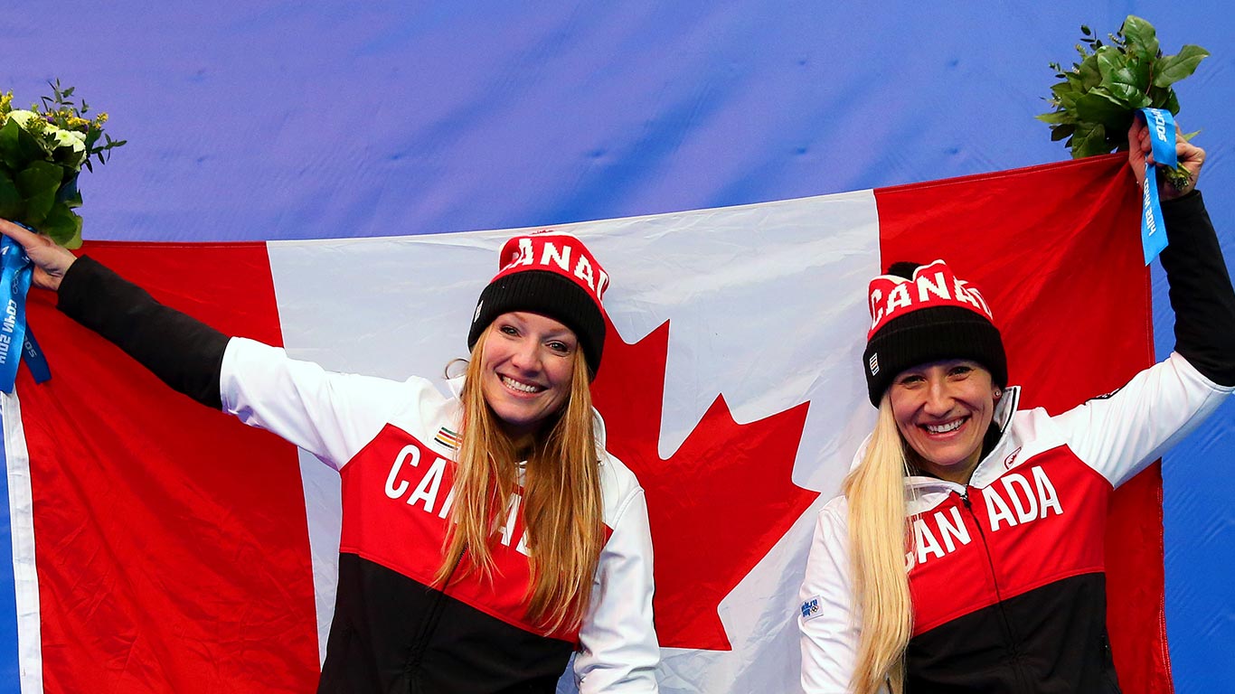 Kaillie Humphries (R) and Heather Moyse of Canada team 1 celebrate during the flower ceremony after winning the gold medal  (© Alex Livesey/Getty Images)(Bing Canada)