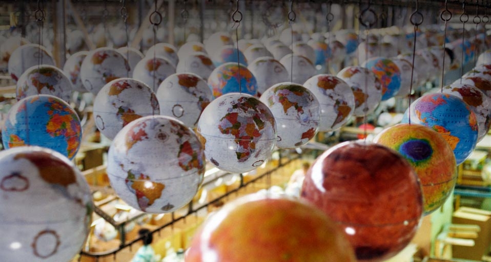Globes suspended from conveyor track at factory -- Andy Sacks/Getty Images &copy; (Bing Canada)