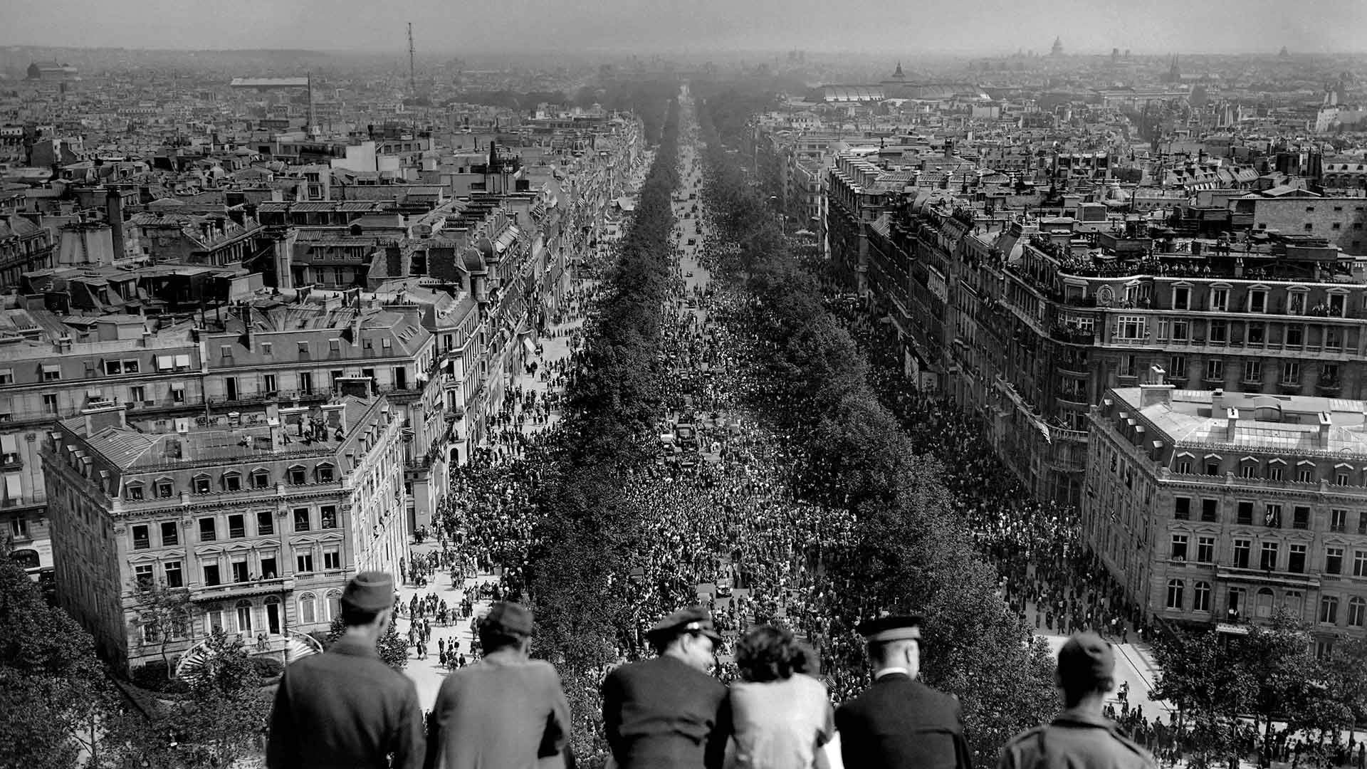 People looking at the crowded Avenue des Champs-Élysées from the Arc de Triomphe on May 8, 1945, Paris, France (© AFP via Getty Images)(Bing Canada)