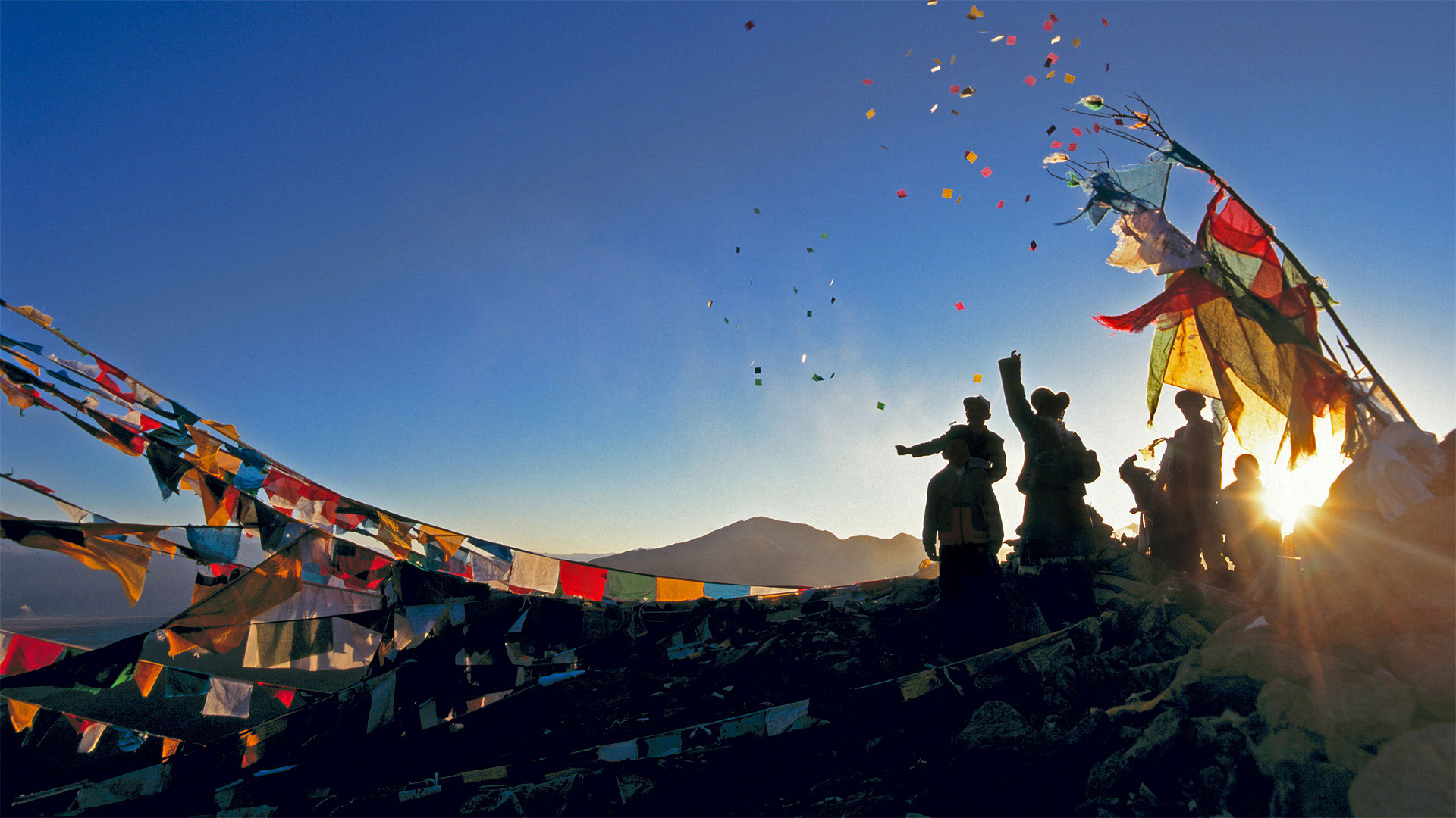 朝圣者将风马旗扔向甘登寺上方的空中为新年祈福，中国西藏 (© Ian Cumming/plainpicture)(Bing China)