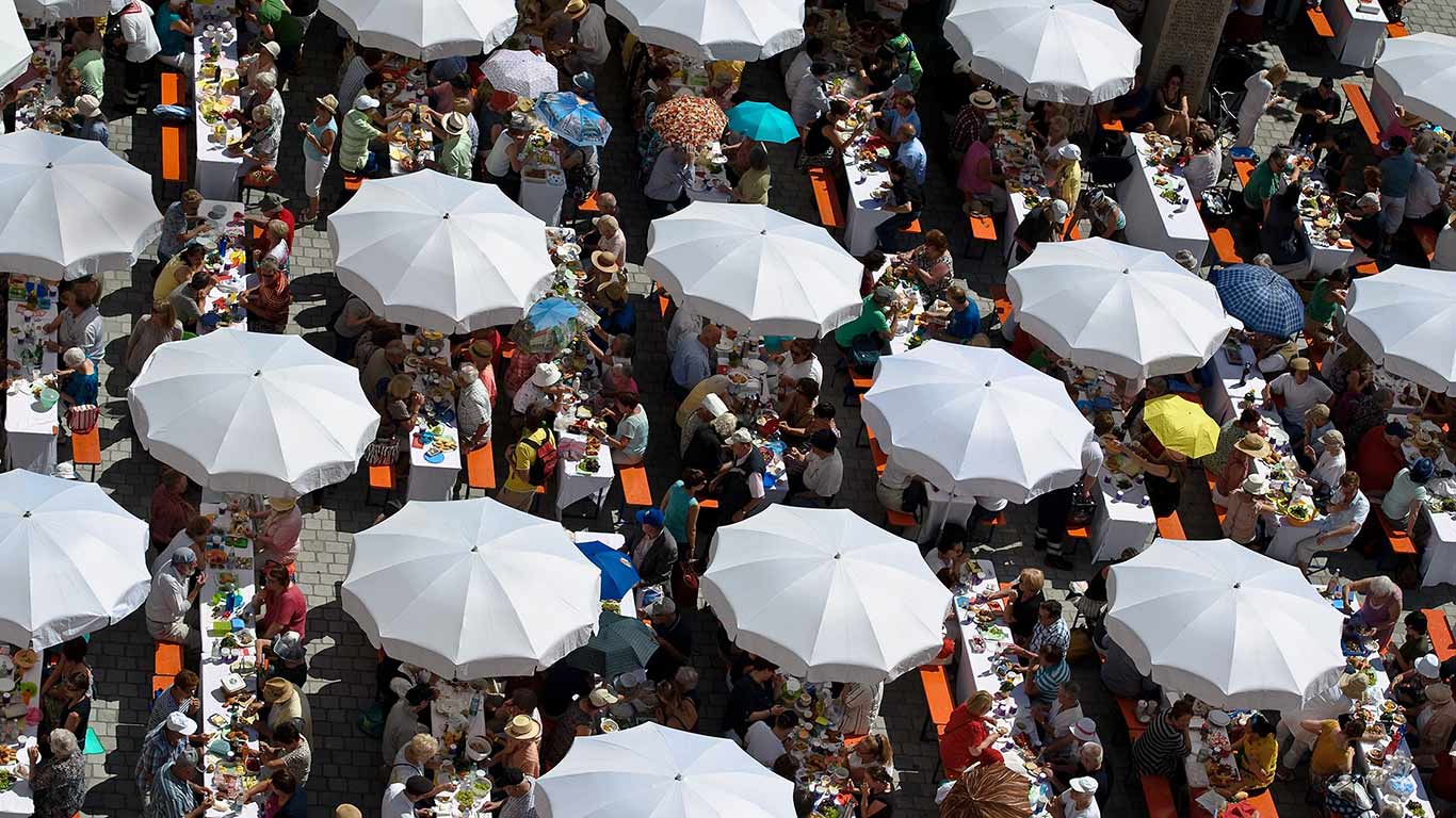 Teilnehmer der Friedenstafel auf dem Rathausplatz in Augsburg, Bayern, während des Augsburger Hohen Friedensfestes am 8. August 2014 (© ANGELIKA WARMUTH/DPA/Getty Images)(Bing Deutschland)