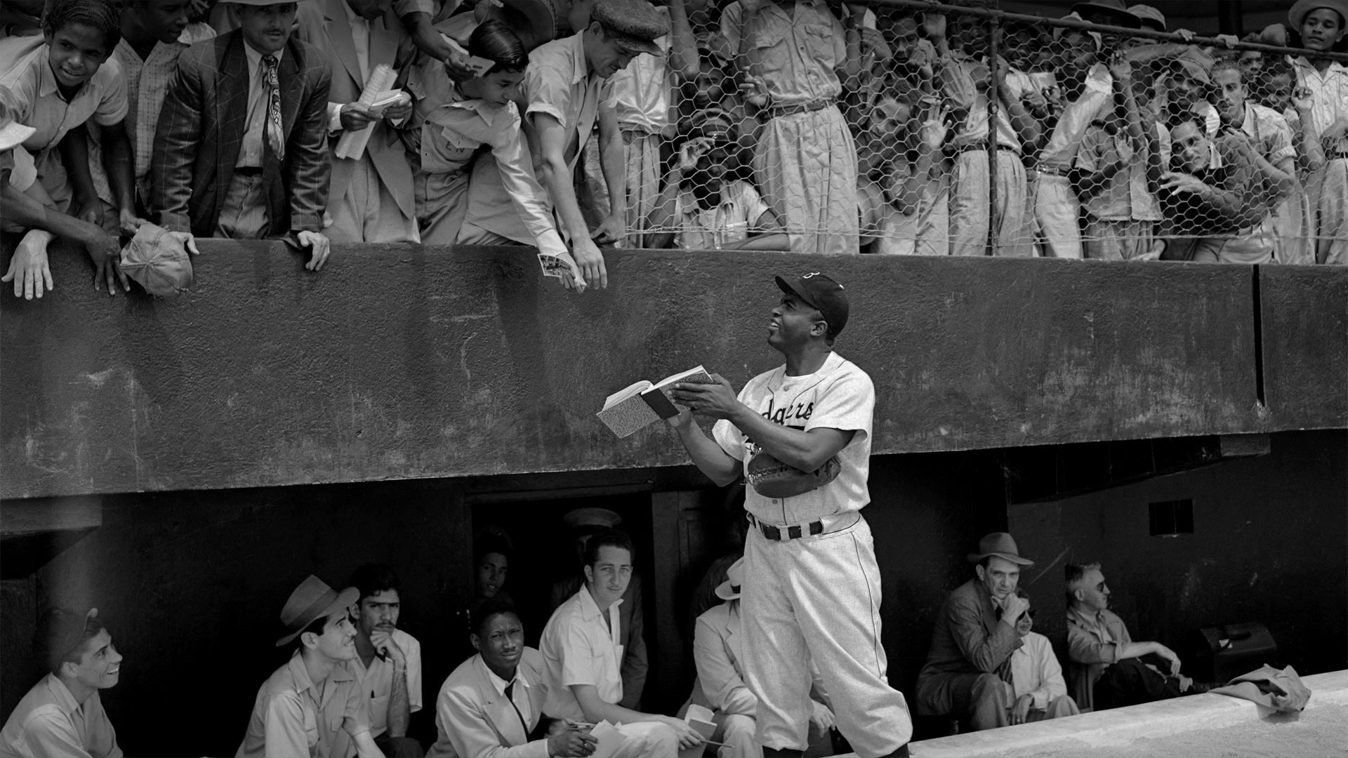 Jackie Robinson signs autographs at spring training in Ciudad Trujillo, now Santo Domingo, Dominican Republic, on March 6, 1948 (© Bettmann/Getty Images)(Bing United States)