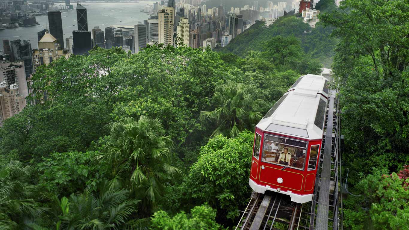红色缆车驶过香港太平山顶，背景为香港城市风光 (© EIGHTFISH/The Image Bank/Getty Images)(Bing China)