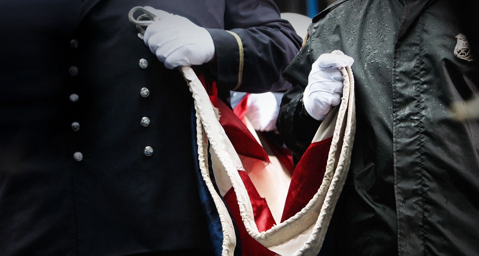Firefighters hold a U.S. flag as they gather to pay their respects at Ground Zero during a 9/11 memorial ceremony on September 11, 2009, in New York City (© Chris Hondors/Getty Images) &copy; (Bing United States)