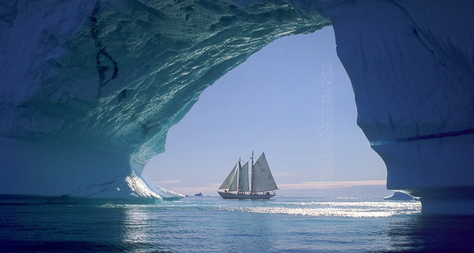 Iceberg arch and sailboat off the coast of Greenland -- Tom Stewart/Photolibrary &copy; (Bing Canada)