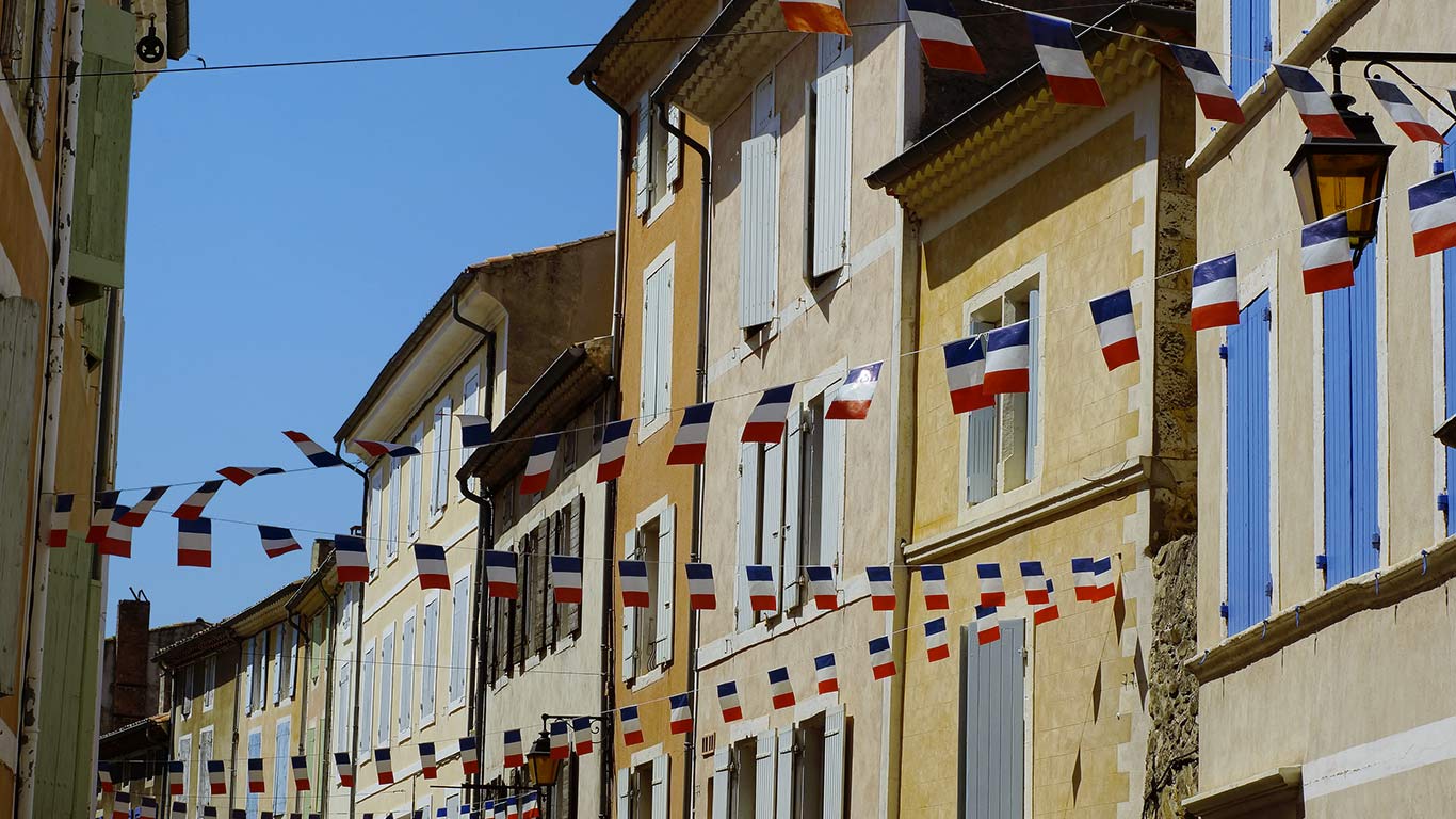 Fanions de drapeaux de la France décorant des immeubles à l’occasion du 14 juillet, Dieulefit, Auvergne-Rhône-Alpes, France (© StockCube/Shutterstock)(Bing France)