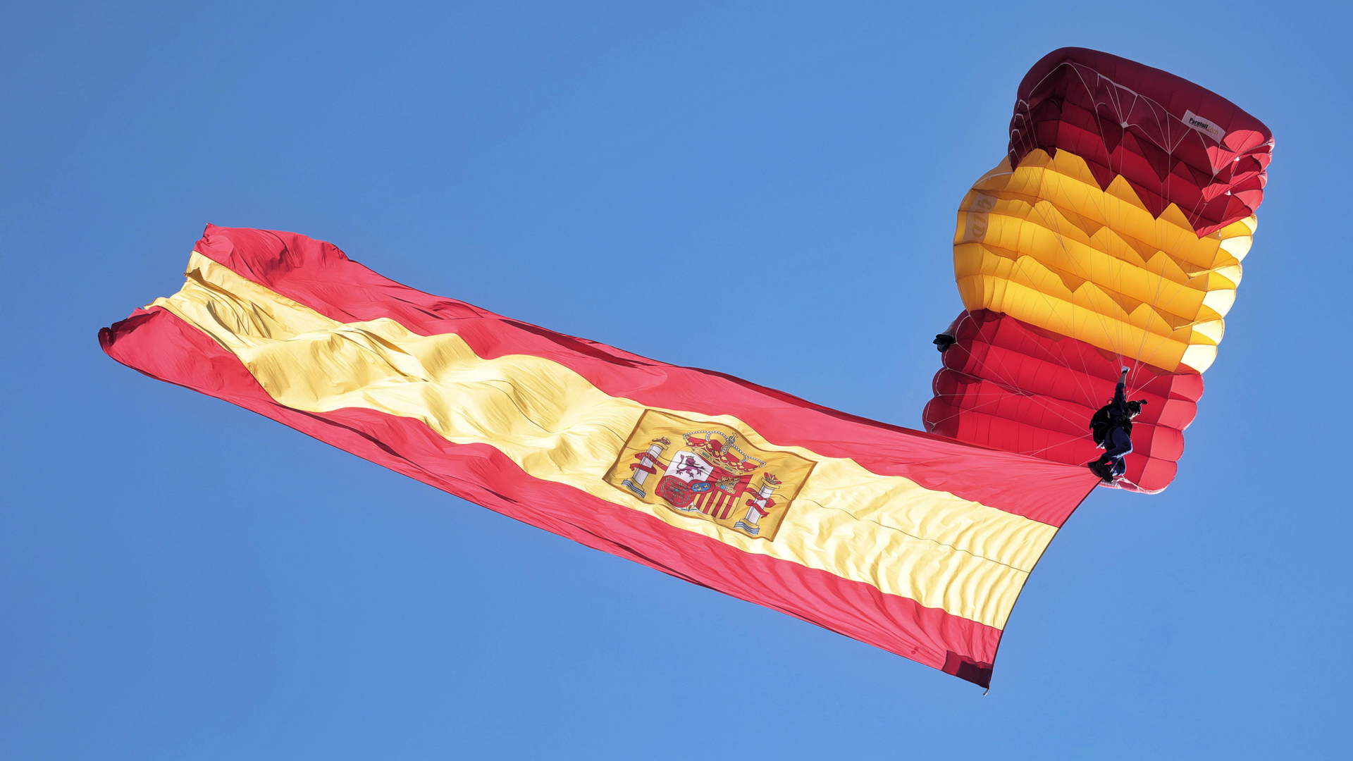 Paracaidista despliega la bandera española en el aire durante el desfile militar en el Día de la Hispanidad, Madrid, España (© Europa Press News/Collaborator)(Bing España)