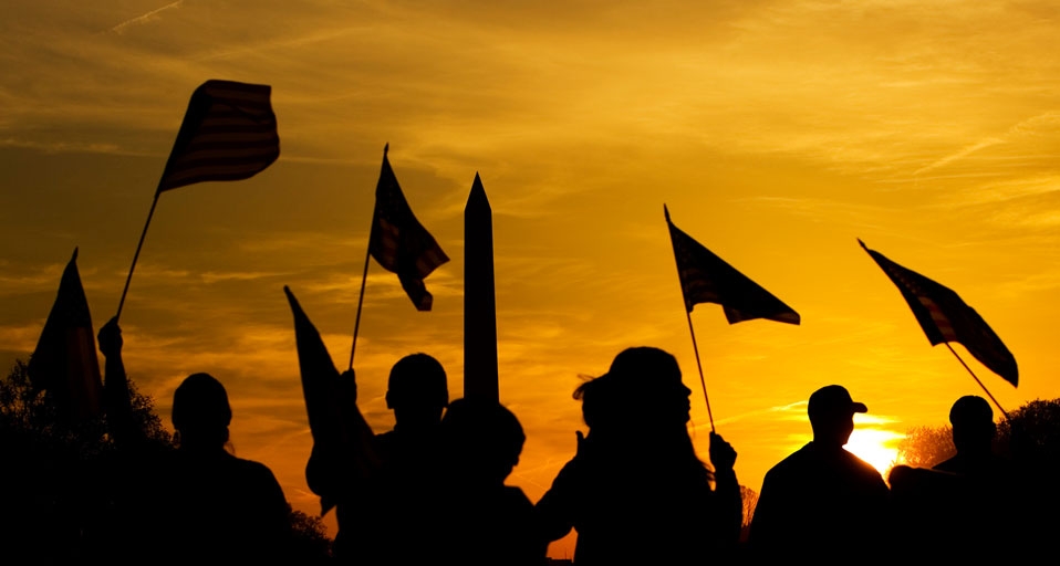 People holding American flags at sunset near the Washington Monument in Washington, D.C. -- Glow Images, Inc/Superstock &copy; (Bing United States)